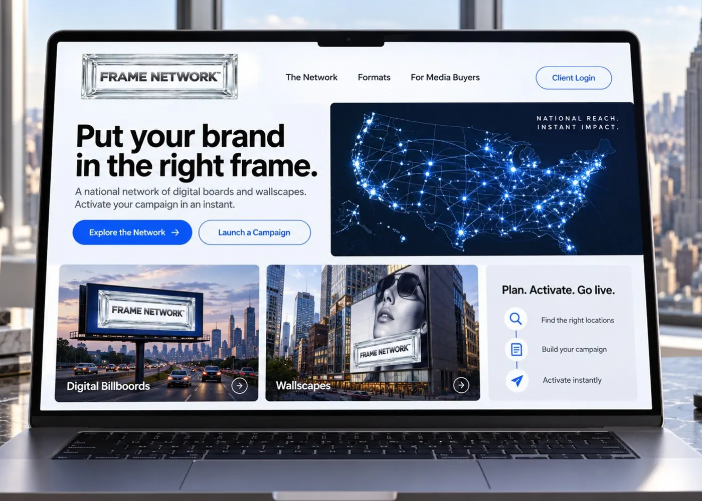 The Frame Network site open on a laptop on a desk, with the city behind the window